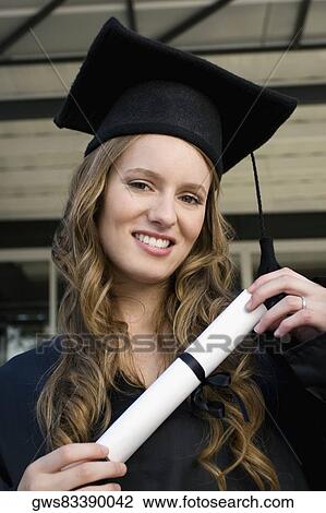 Portrait of a graduate student holding a diploma and smiling View Large Photo Image Stock Image - Portrait of a graduate student holding a diploma and smiling. Fotosearch