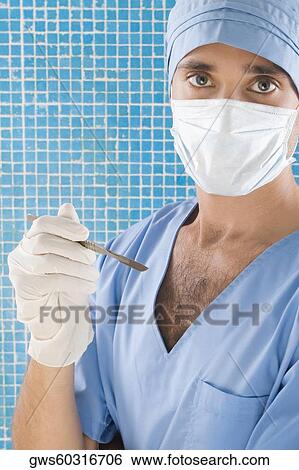 Portrait of a male surgeon holding a scalpel View Large Photo Image Stock Photograph - Portrait of a male surgeon holding a scalpel. Fotosearch