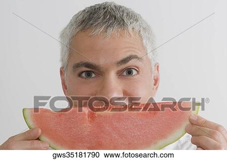 Portrait of a mature man eating a slice of watermelon View Large Photo Image Stock Image - Portrait of a mature man eating a slice of watermelon. Fotosearch