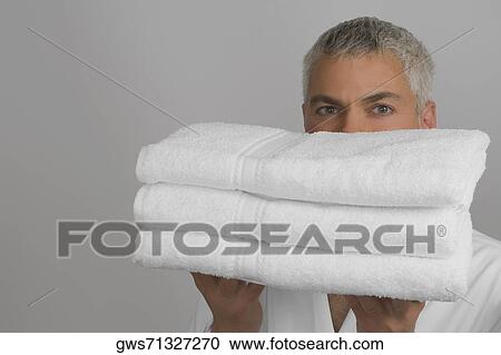 Portrait of a mature man holding a stack of folded towels View Large Photo Image Stock Image - Portrait of a mature man holding a stack of folded towels. Fotosearch
