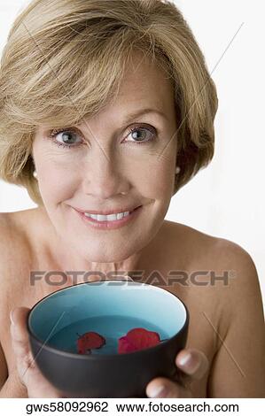 Portrait of a mature woman holding a bowl of water with floating petals View Large Photo Image Stock Image - Portrait of a mature woman holding a bowl of water with floating petals. Fotosearch