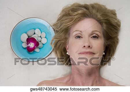 Stock Photography - Portrait of a mature woman lying on a massage table. Fotosearch