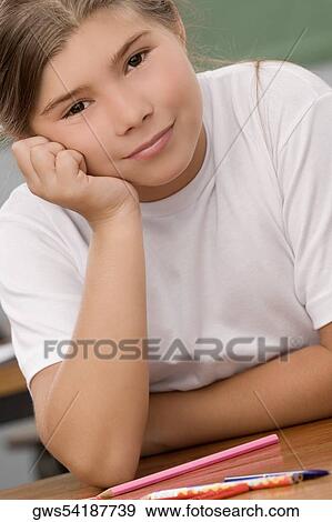 Portrait of a schoolgirl smiling with her hand on her chin View Large Photo Image Stock Photo - Portrait of a schoolgirl smiling with her hand on her chin. Fotosearch