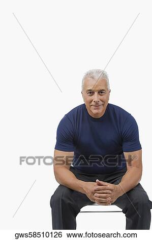 Stock Photograph - Portrait of a senior man sitting with his hands clasped and smiling. Fotosearch