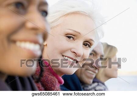 Portrait of a senior woman smiling with her friends View Large Photo Image Stock Image - Portrait of a senior woman smiling with her friends. Fotosearch