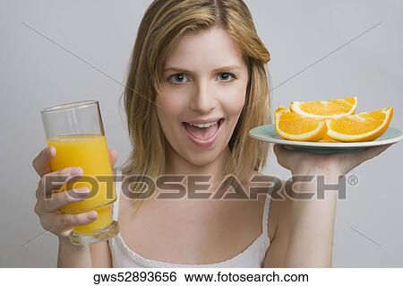 Portrait of a teenage girl holding a plate of oranges and a glass of orange juice View Large Photo Image Stock Photograph - Portrait of a teenage girl holding a plate of oranges and a glass of orange juice. Fotosearch