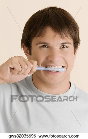 Portrait of a young man brushing his teeth View Large Photo Image Stock Photography - Portrait of a young man brushing his teeth. Fotosearch