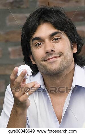 Portrait of a young man holding a paper ball and smirking View Large Photo Image Stock Photo - Portrait of a young man holding a paper ball and smirking. Fotosearch