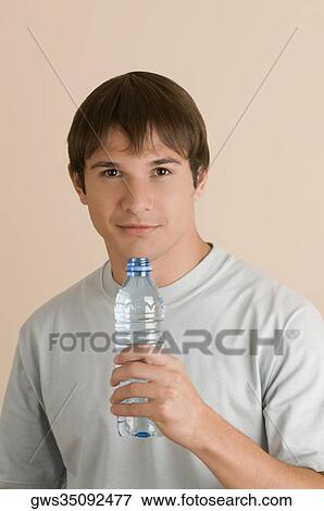 Portrait of a young man holding a water bottle View Large Photo Image Stock Photo - Portrait of a young man holding a water bottle. Fotosearch