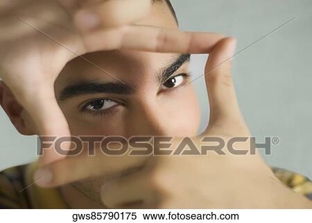 Portrait of a young man making a finger frame View Large Photo Image Stock Photography - Portrait of a young man making a finger frame. Fotosearch