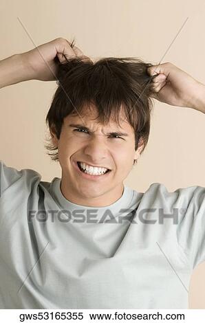 Portrait of a young man pulling his hair View Large Photo Image Stock Photography - Portrait of a young man pulling his hair. Fotosearch