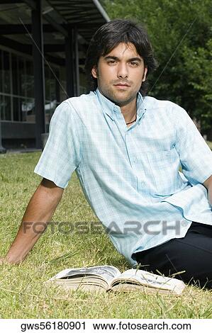 Portrait of a young man sitting in a lawn View Large Photo Image Stock Image - Portrait of a young man sitting in a lawn. Fotosearch