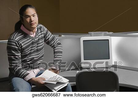 Portrait of a young man sitting in a computer lab and holding a book View Large Photo Image Stock Photo - Portrait of a young man sitting in a computer lab and holding a book. Fotosearch