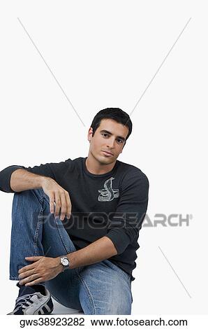 Portrait of a young man sitting with his hand on his knee View Large Photo Image Stock Image - Portrait of a young man sitting with his hand on his knee. Fotosearch