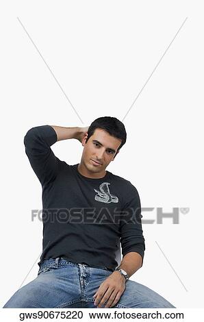 Portrait of a young man sitting with his hand in his hair View Large Photo Image Stock Image - Portrait of a young man sitting with his hand in his hair. Fotosearch