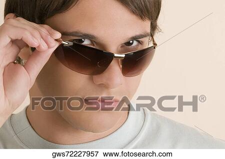 Portrait of a young man wearing sunglasses View Large Photo Image Stock Photo - Portrait of a young man wearing sunglasses. Fotosearch