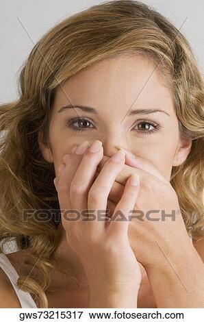 Portrait of a young woman covering her mouth with her hands View Large Photo Image Stock Photo - Portrait of a young woman covering her mouth with her hands. Fotosearch