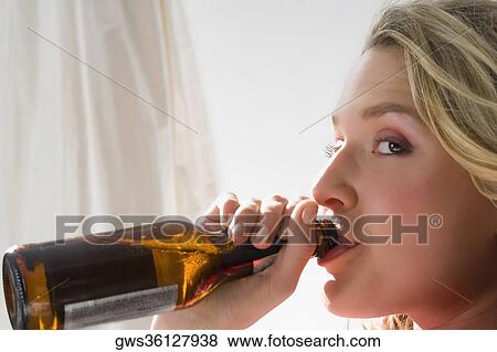 Stock Photo - Portrait of a young woman drinking beer. Fotosearch