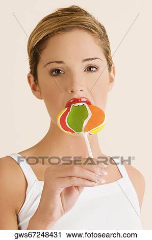 Portrait of a young woman eating a lollipop View Large Photo Image Stock Image - Portrait of a young woman eating a lollipop. Fotosearch