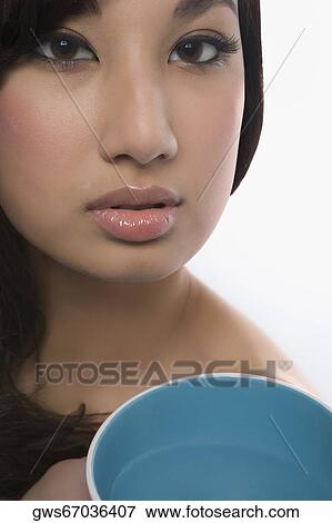 Portrait of a young woman holding a bowl View Large Photo Image Stock Photo - Portrait of a young woman holding a bowl. Fotosearch