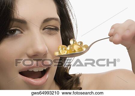 Portrait of a young woman holding a spoon full of pills View Large Photo Image Stock Image - Portrait of a young woman holding a spoon full of pills. Fotosearch