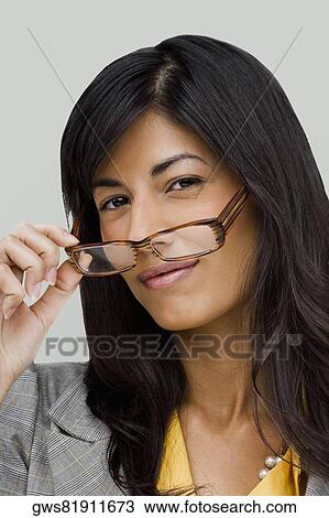 Portrait of a young woman holding a pair of eyeglasses View Large Photo Image Stock Image - Portrait of a young woman holding a pair of eyeglasses. Fotosearch