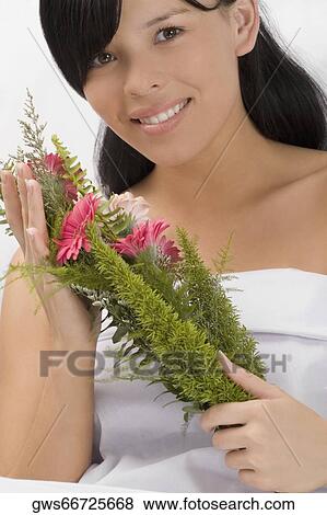 Portrait of a young woman holding a bouquet and smiling View Large Photo Image Stock Photo - Portrait of a young woman holding a bouquet and smiling. Fotosearch