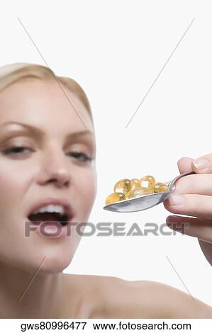 Portrait of a young woman holding a spoon full of pills View Large Photo Image Stock Photo - Portrait of a young woman holding a spoon full of pills. Fotosearch