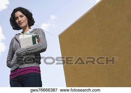 Portrait of a young woman holding books View Large Photo Image Stock Photo - Portrait of a young woman holding books. Fotosearch