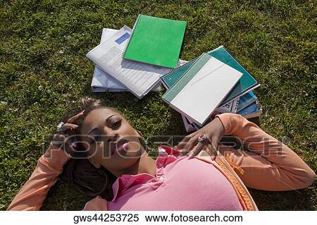 Portrait of a young woman lying on grass View Large Photo Image Stock Photography - Portrait of a young woman lying on grass. Fotosearch
