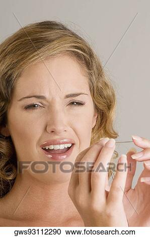 Portrait of a young woman pinching her finger with a needle View Large Photo Image Stock Image - Portrait of a young woman pinching her finger with a needle. Fotosearch