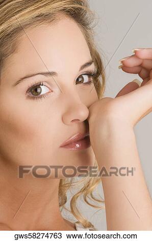 Portrait of a young woman rubbing her nose View Large Photo Image Stock Image - Portrait of a young woman rubbing her nose. Fotosearch
