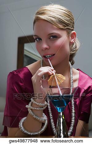Portrait of a young woman sipping a cocktail View Large Photo Image Stock Photo - Portrait of a young woman sipping a cocktail. Fotosearch