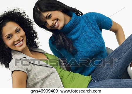 Portrait of a young woman sitting in an armchair with her friend sitting on her lap View Large Photo Image Stock Photo - Portrait of a young woman sitting in an armchair with her friend sitting on her lap. Fotosearch