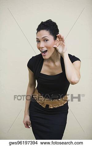 Portrait of a young woman with her hand close to her ear View Large Photo Image Picture - Portrait of a young woman with her hand close to her ear. Fotosearch