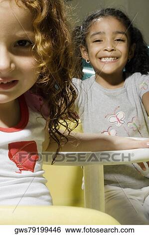 Stock Photograph - Portrait of two girls in a toy car. Fotosearch