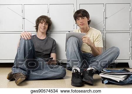 Portrait of two high school students sitting in front of lockers View Large Photo Image Picture - Portrait of two high school students sitting in front of lockers. Fotosearch