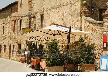 Potted plants and patio umbrellas in front of a building, Piazza Roma, Monteriggioni, Siena Province, Tuscany, Italy View Large Photo Image Stock Photography - Potted plants and patio umbrellas in front of a building, Piazza Roma, Monteriggioni, Siena Province, Tuscany, Italy. Fotosearch