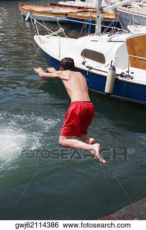 Rear view of a boy jumping in water, Borgo Marinaro, Bay of Naples, Naples, Naples Province, Campania, Italy View Large Photo Image Stock Photograph - Rear view of a boy jumping in water, Borgo Marinaro, Bay of Naples, Naples, Naples Province, Campania, Italy. Fotosearch