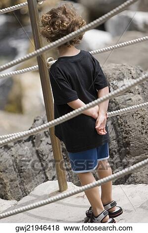 Rear view of a boy standing on steps with his hands behind back, Italian Riviera, Cinque Terre National Park, Vernazza, La Spezia, Liguria, Italy View Large Photo Image Stock Photo - Rear view of a boy standing on steps with his hands behind back, Italian Riviera, Cinque Terre National Park, Vernazza, La Spezia, Liguria, Italy. Fotosearch