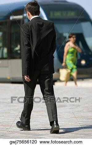 Rear view of a businessman walking on a sidewalk, Bordeaux, Aquitaine, France View Large Photo Image Stock Image - Rear view of a businessman walking on a sidewalk, Bordeaux, Aquitaine, France. Fotosearch
