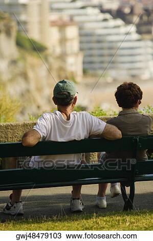 Rear view of a couple sitting on a bench, St. Martin, Biarritz, France View Large Photo Image Stock Image - Rear view of a couple sitting on a bench, St. Martin, Biarritz, France. Fotosearch