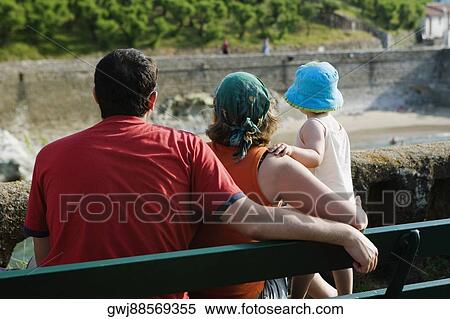 Rear view of a family on a bench, Biarritz, Basque Country, Pyrenees-Atlantiques, Aquitaine, France View Large Photo Image Stock Photography - Rear view of a family on a bench, Biarritz, Basque Country, Pyrenees-Atlantiques, Aquitaine, France. Fotosearch