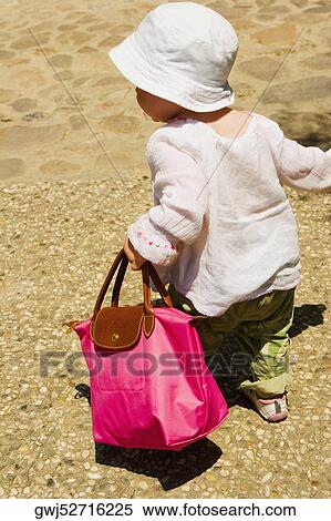 Rear view of a girl carrying a hand, Monteriggioni, Siena Province, Tuscany, Italy View Large Photo Image Stock Photography - Rear view of a girl carrying a hand, Monteriggioni, Siena Province, Tuscany, Italy. Fotosearch
