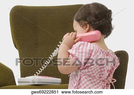 Rear view of a girl playing with a toy phone View Large Photo Image Stock Image - Rear view of a girl playing with a toy phone. Fotosearch