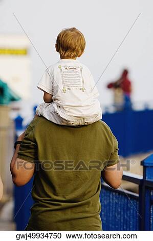 Rear view of a man carrying his son on shoulders, Promenade des Anglais, Nice, Provence-Alpes-Cote D'Azur, France View Large Photo Image Stock Image - Rear view of a man carrying his son on shoulders, Promenade des Anglais, Nice, Provence-Alpes-Cote D'Azur, France. Fotosearch