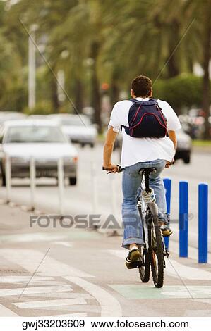 Rear view of a man riding a bicycle, Promenade des Anglais, Nice, Provence-Alpes-Cote D'Azur, France View Large Photo Image Stock Photo - Rear view of a man riding a bicycle, Promenade des Anglais, Nice, Provence-Alpes-Cote D'Azur, France. Fotosearch