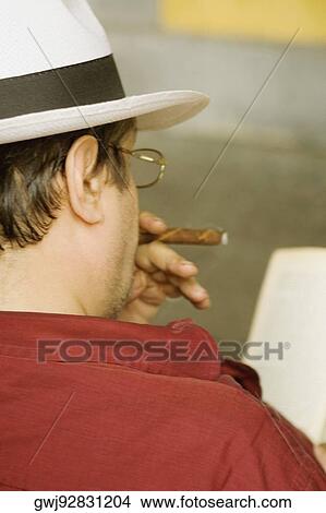 Rear view of a man smoking a cigar, Piazza Colombo, Mercato Orientale, Genoa, Italy View Large Photo Image Picture - Rear view of a man smoking a cigar, Piazza Colombo, Mercato Orientale, Genoa, Italy. Fotosearch