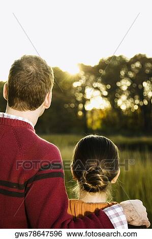 Stock Photograph - Rear view of a mid adult couple looking at view. Fotosearch