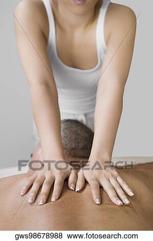 Rear view of a senior man getting a back massage from a massage therapist View Large Photo Image Stock Photo - Rear view of a senior man getting a back massage from a massage therapist. Fotosearch